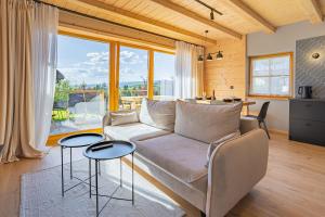 a living room with a couch and two tables at Osada Przystanek Czorsztyn in Czorsztyn