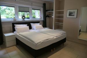 een slaapkamer met een bed met witte lakens en kussens bij Kunsthof Salsitz in Lohme