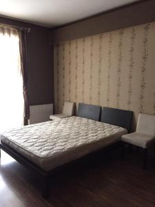 1 dormitorio con 1 cama, 1 silla y 1 ventana en Hatai Avenue 38 Apartment, en Baku