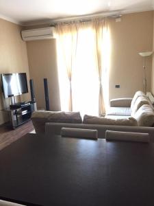 sala de estar con sofá y ventana grande en Hatai Avenue 38 Apartment, en Baku