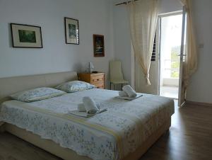 a bedroom with a bed with two towels on it at Borovik Guest House in Živogošće