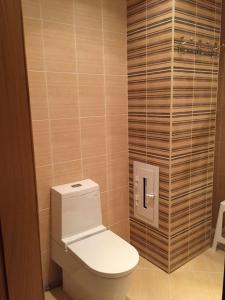 baño con aseo y pared de madera en Hatai Avenue 38 Apartment, en Baku