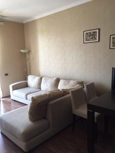 a living room with a couch and a table at Hatai Avenue 38 Apartment in Baku