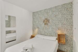 1 dormitorio con cama blanca y pared en Apartamento Con Encanto, en Maspalomas 14 fotos más