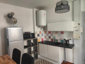 a kitchen with a refrigerator and a table and chairs at le paradis perdù in Le Puy-en-Velay
