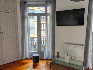 a living room with a glass table and a large window at le paradis perdù in Le Puy-en-Velay