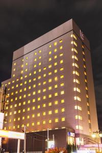 a tall building with yellow lights on it at Hotel Sunroute Niigata in Niigata