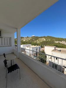 a table and a chair on a balcony with a view at Résidence Eddyr in Sicca Veneria