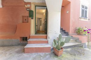 a house with stairs and a cactus in front of it at Emma House Terrace and Sea View Moneglia in Moneglia