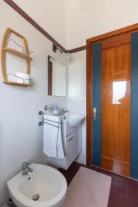 Un baño con inodoro, lavabo y espejo. en Terranova Home vista mare, en San Leone 70 fotos más