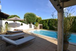 a pool with two lounge chairs and an umbrella at La Lézarde, chambre d'hôte, piscine, salle d'eau privatif, café ou thé offert le matin in Saint-Victor-la-Coste