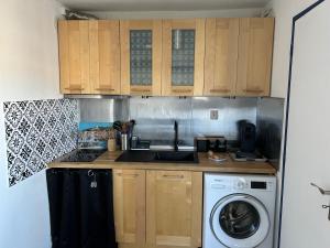 a kitchen with wooden cabinets and a washing machine at Studio cabine avec vue sur le port in Gruissan +8 photos