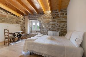 ein Schlafzimmer mit einem großen Bett in einem Steinzimmer in der Unterkunft Country House - Casa Da Marquinhas in Lama de Ouriço + 36 Fotos
