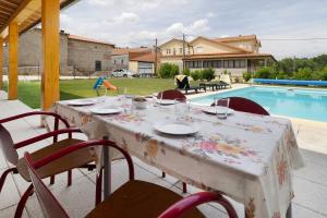 ein Tisch mit einem Tischtuch darauf neben einem Pool in der Unterkunft Country House - Casa Da Marquinhas in Lama de Ouriço