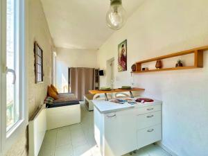una pequeña cocina con encimera y mesa en Le Notre Dame, Studio à 400m des Arènes de Nîmes, en Nimes