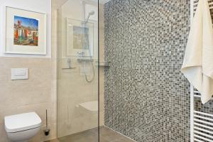Un baño con inodoro y ducha de cristal. en Penthouse Hafenkieker, en Putbus 9 fotos más