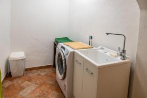 a laundry room with a washing machine and a sink at Casetta Vacanze - Appartamento con 2 camere da letto in Frasso Telesino