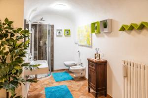 a bathroom with a toilet and a shower with blue mats at Casetta Vacanze - Appartamento con 2 camere da letto in Frasso Telesino +40 photos
