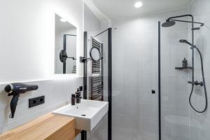 a bathroom with a sink and a shower at Limehome Krems Undstraße in Krems an der Donau +42 photos