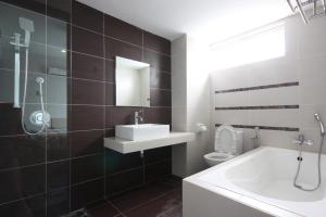 a bathroom with a sink and a tub and a toilet at Shamrock Beach Villas 15 Seaview in George Town +28 photos