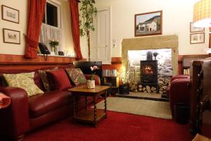 ein Wohnzimmer mit Couch und Kamin in der Unterkunft Traditional 2 Bedroom Cottage in Eyam Hope Valley in Eyam