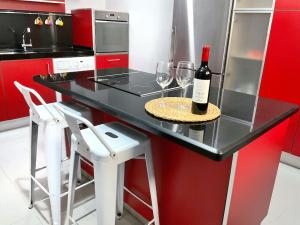 Un mostrador negro con una botella de vino y dos copas de vino. en Casa de la lonja, en Fondón 37 fotos más