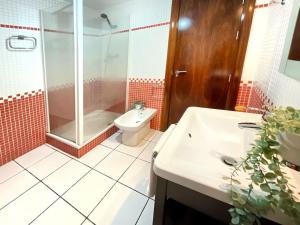 Un baño con inodoro, ducha y lavabo. en Casa de la lonja, en Fondón