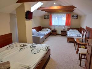 a room with two beds and a table and chairs at Willa Onyks in Szklarska Poręba