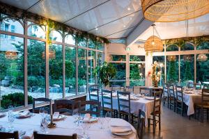 une salle à manger avec tables, chaises et fenêtres dans l'établissement Domaine La Gentilhommière, à Satillieu