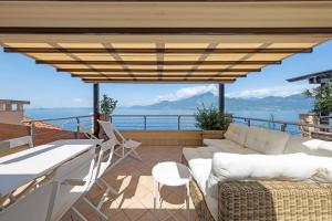 a patio with a couch and a table at ApartmentsGarda - Il Tesoro del Lago in Torri del Benaco