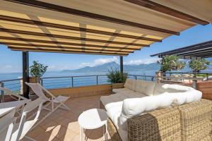 a living room with a couch and a view of the ocean at ApartmentsGarda - Il Tesoro del Lago in Torri del Benaco +23 photos