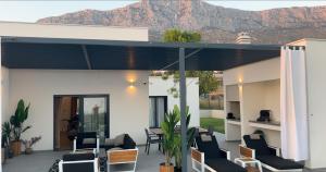 ein Haus mit einer Terrasse mit Bergen im Hintergrund in der Unterkunft Villa Porto Recupera in Kaštela