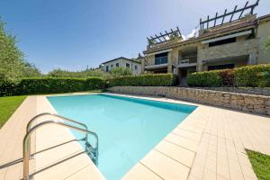 a swimming pool in front of a house at ApartmentsGarda - Il Tesoro del Lago in Torri del Benaco