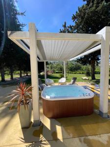 a hot tub under a pavilion with chairs under it at Villa Berenice House and Relax in San Giovanni Teatino +19 photos
