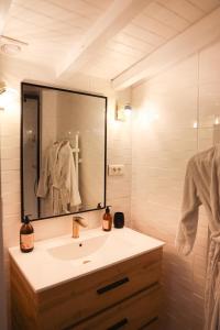 a bathroom with a sink and a large mirror at Chalet Romantique in Marions
