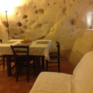 a dining room with two tables and a rock wall at A Casa di Irene in Matera