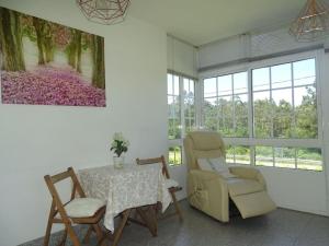 a dining room with a table and two chairs and a painting at Casa vacacional amplia in Carracedo