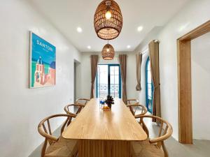 Un comedor con mesa y sillas de madera. en Santorini Villa Tam Dao - Venuestay, en Vĩnh Phúc