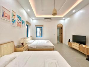 Un dormitorio con dos camas y un televisor de pantalla plana. en Santorini Villa Tam Dao - Venuestay, en Vĩnh Phúc