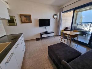 TV/trung tâm giải trí tại שקיעה מול הים - דירה מקסימה במרינה לחוף הים התיכון