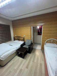 a bedroom with two beds and a chair in it at AVRUPA APART HOSTEL in Seyhan
