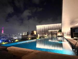 una piscina en la parte superior de un edificio por la noche en Luxury The MarQ-Free Infinity Pool, GYM & BBQ-D1, en Ho Chi Minh 26 fotos más