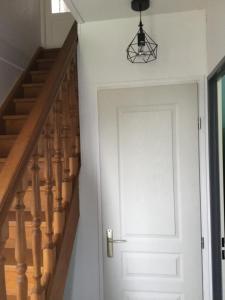 a hallway with a white door and stairs at Maison 1er étage chéreng 6kms stade Pierre Mauroy 4 personnes in Chéreng