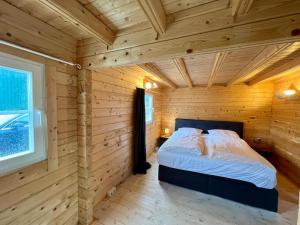 a bedroom with a bed in a wooden room at Ferienhäuser Altes Land in Jork