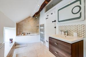 a bathroom with a sink and a tub and a shower at River Fishing I Hot tub I Games Room I PetFriendly in Rainow +100 photos
