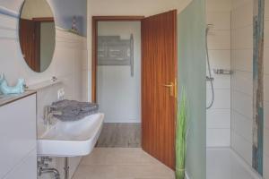 Un baño con lavabo, inodoro y ducha. en Landhaus Sonnenglück, en Tetenbüll