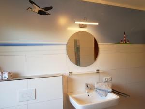 un baño con lavabo y espejo en Landhaus Sonnenglück, en Tetenbüll