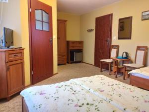 a bedroom with two beds and a tv and a desk at Willa Onyks in Szklarska Poręba