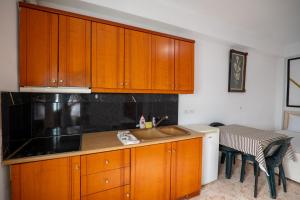 a kitchen with wooden cabinets and a sink and a table at Garden Villa Lake Side & Glamping in Ksamil +163 photos