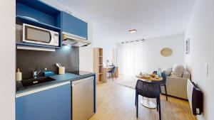 a kitchen and a living room with a small table at Sweetly I-Art Gradignan - Bordeaux Sud in Gradignan